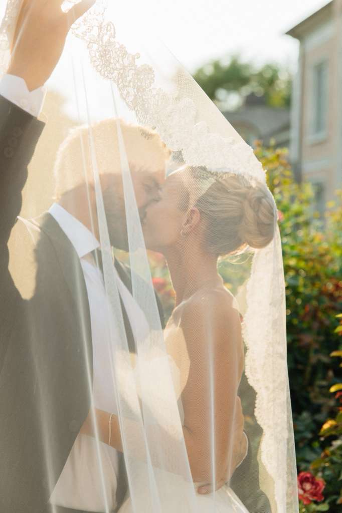 Bride and groom sharing a kiss under her veil