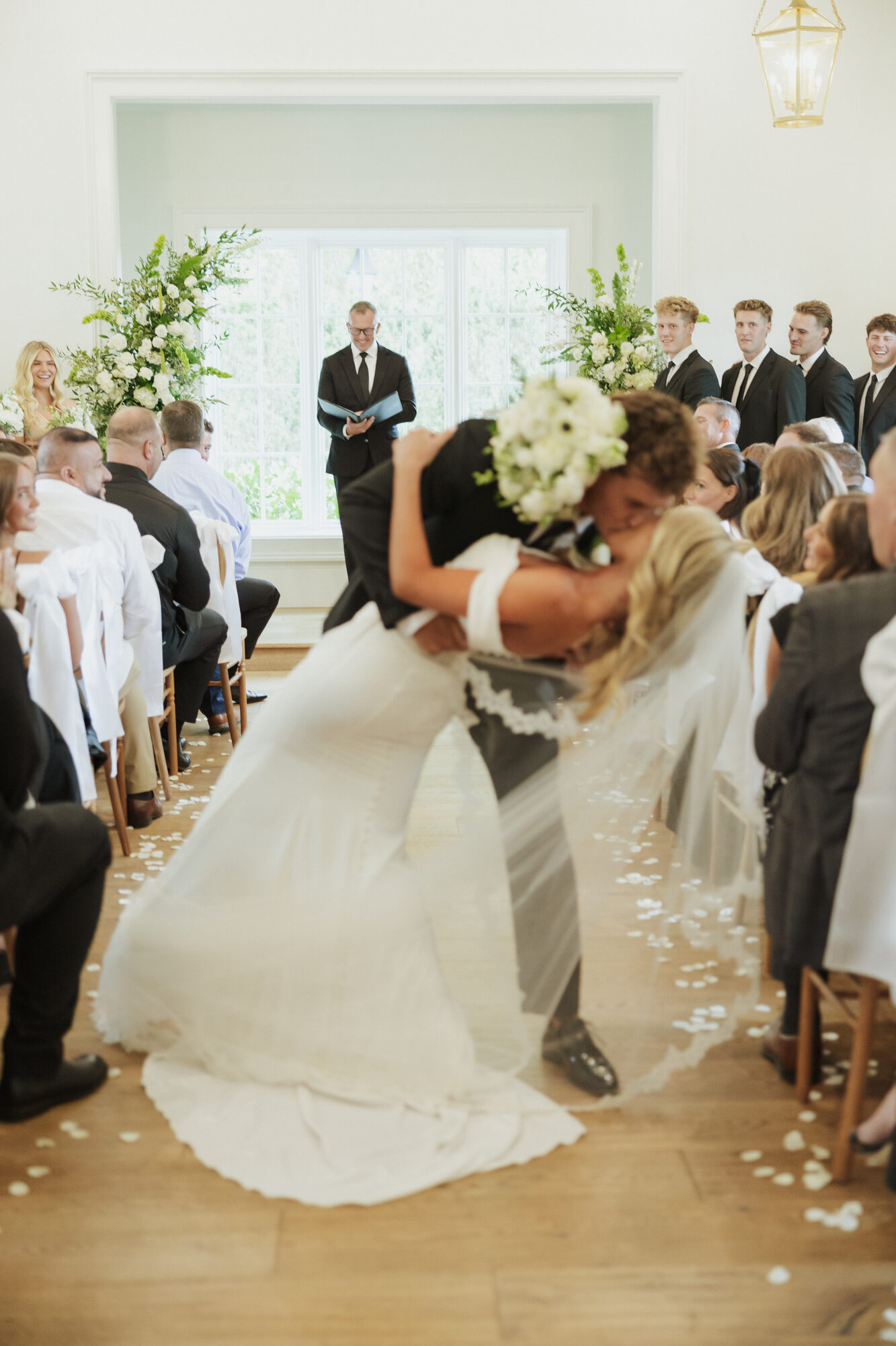Bride and groom kissing at the ceremony aisle